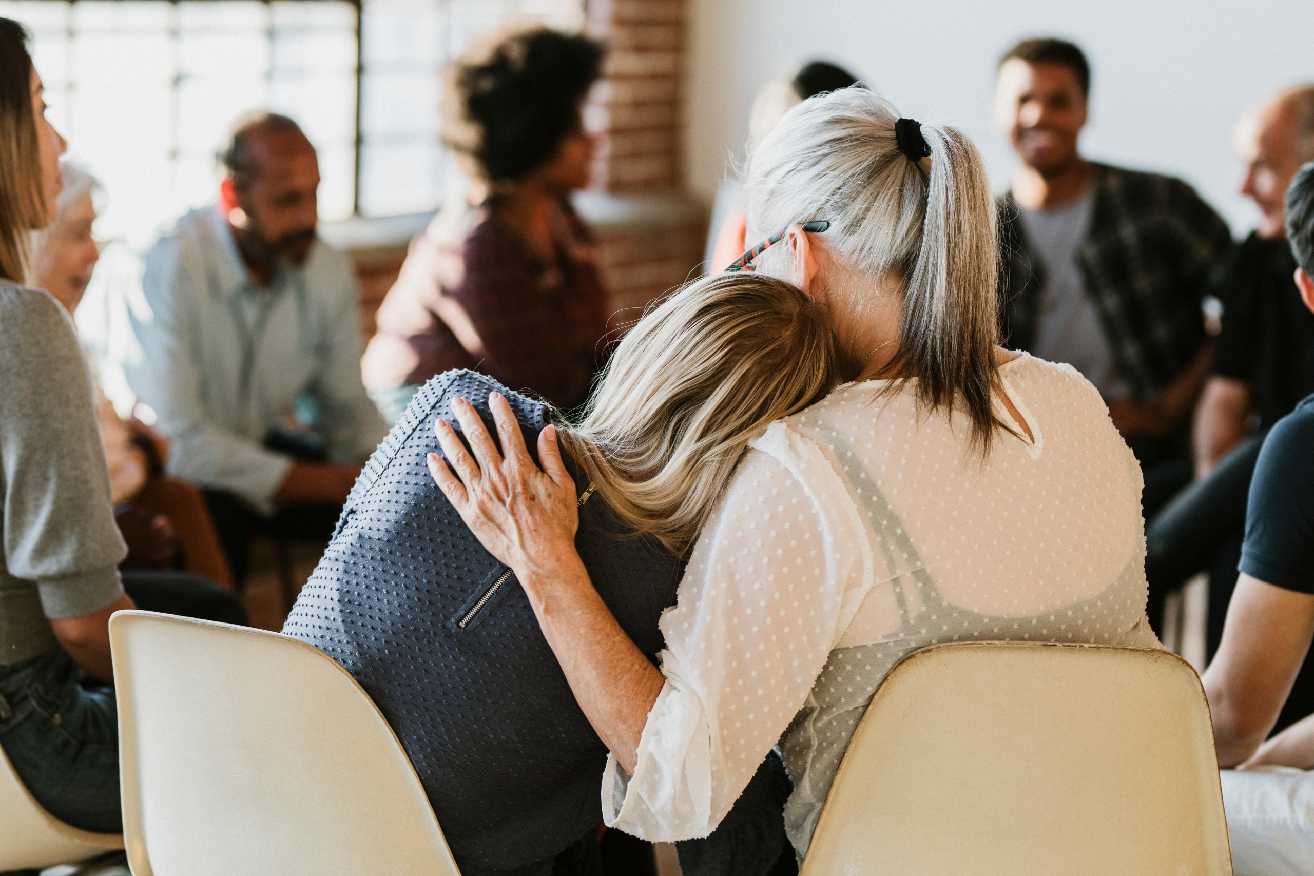 Supporting Each Other – Group therapy Two women supporting each other in a group therapy session