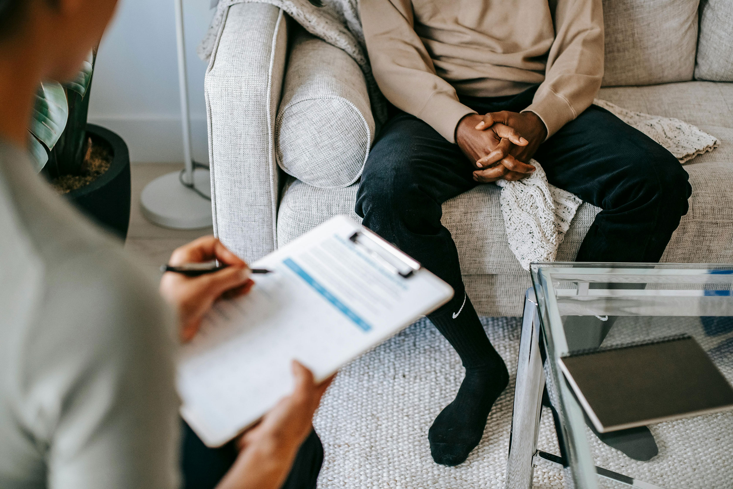 Connect – Wellpath Counseling A person sitting on a couch with another person across from them taking notes